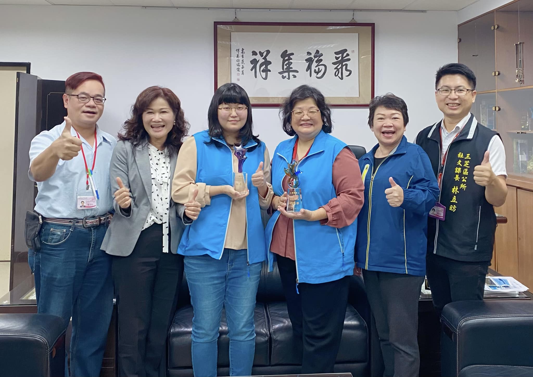 賴區長及主秘與課長和績優社政人員合影